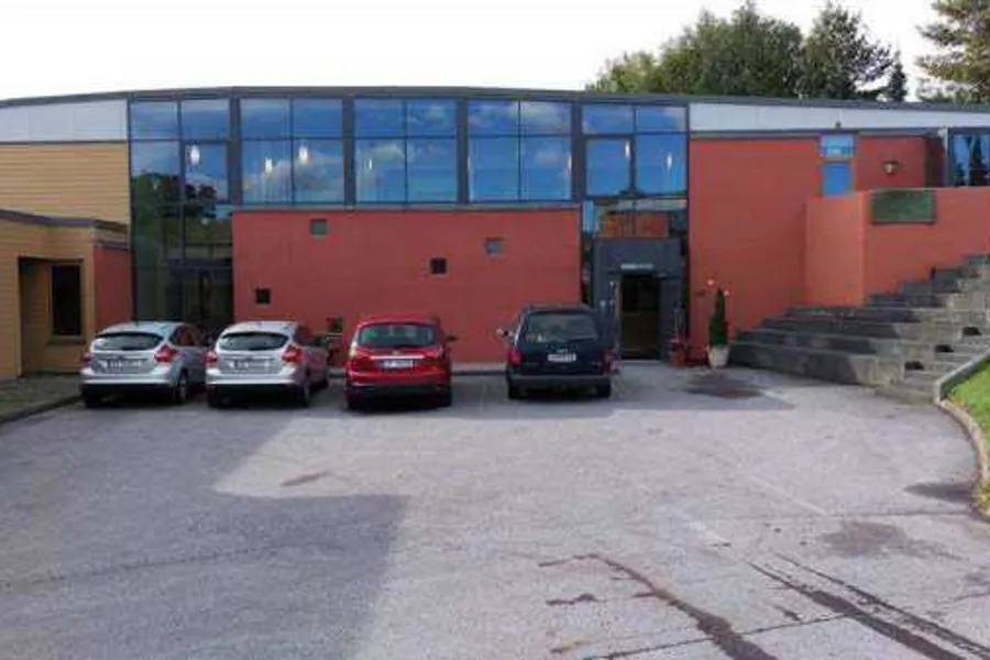 En bygning med biler parkert foran