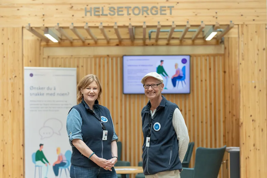 En mann og en kvinne som står foran et skilt