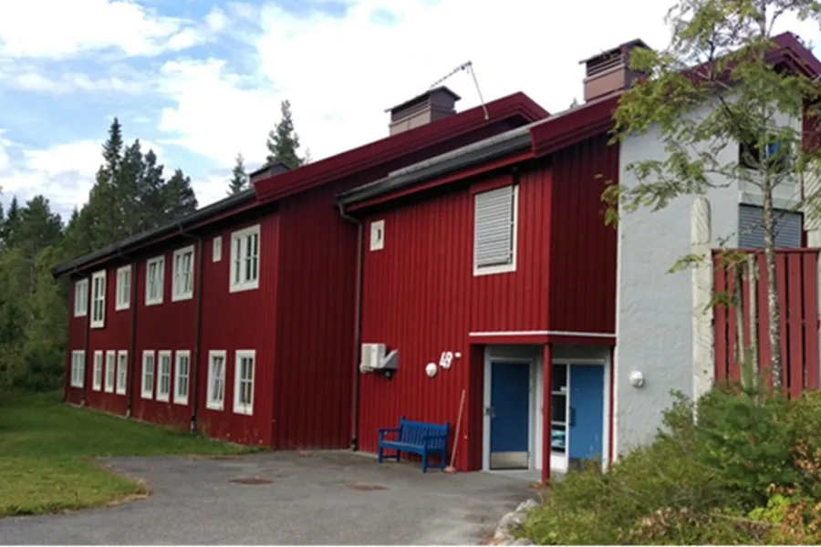 En rød låve med en blå benk