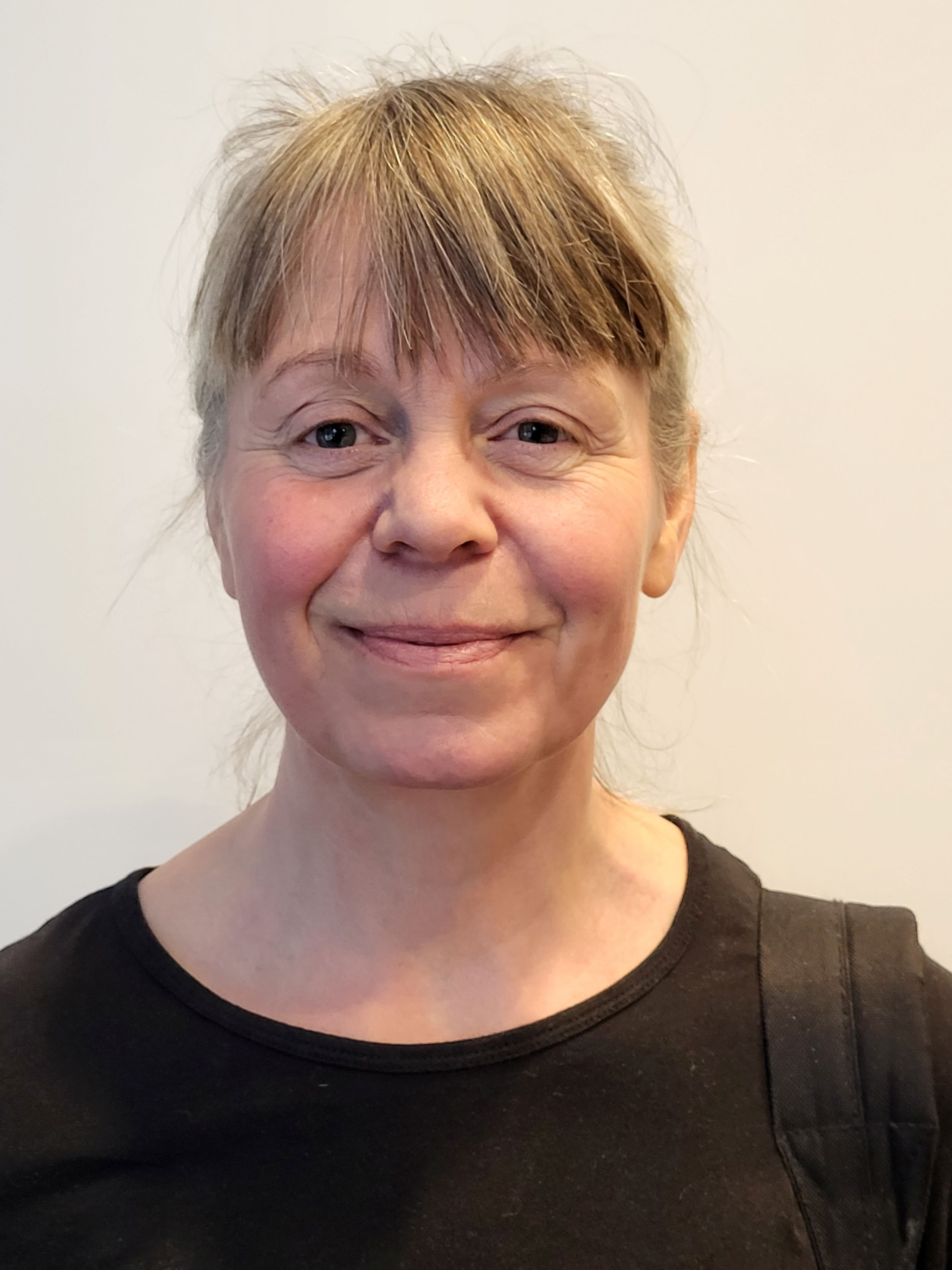 En kvinne som smiler til kameraet