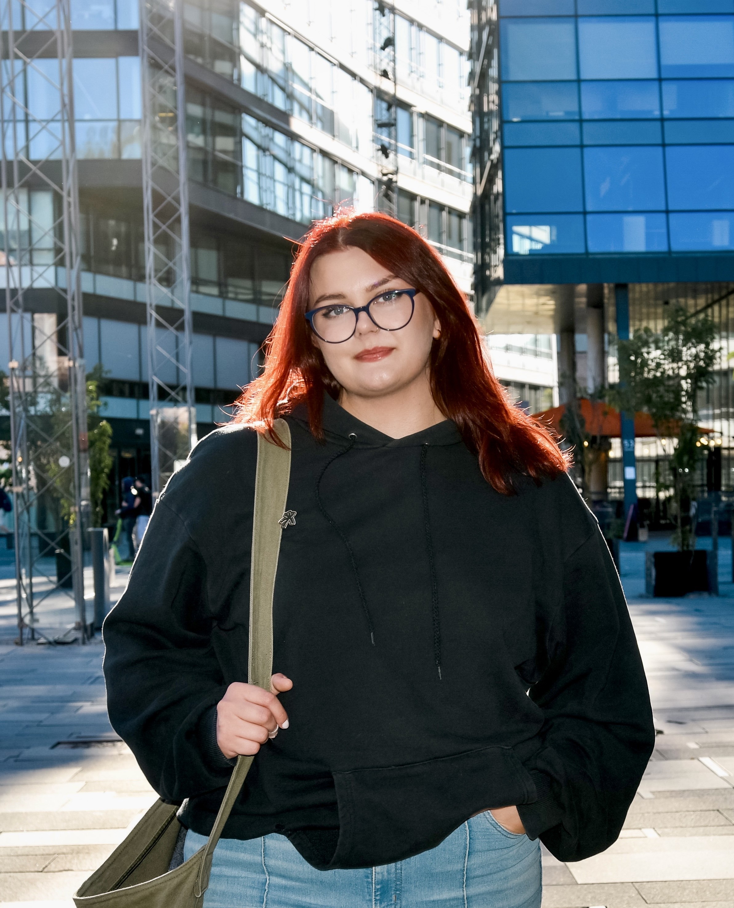 En kvinne med rødt hår og briller