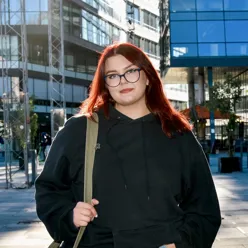 En kvinne med rødt hår og briller