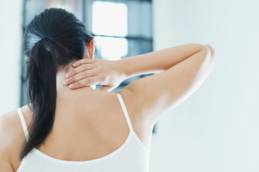 Kvinne tar seg til nakken