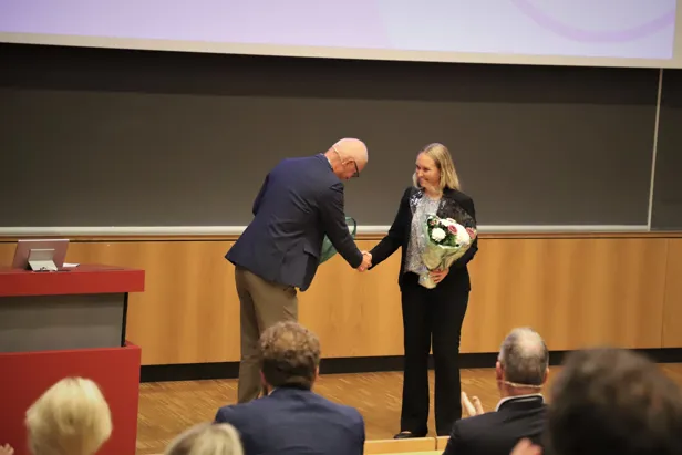 Helsedirektør Bjørn Guldvåg gir blomster til Kristin Randel, nasjonal koordinator og leder av Tarmscreeningseksjonen i Kreftregisteret