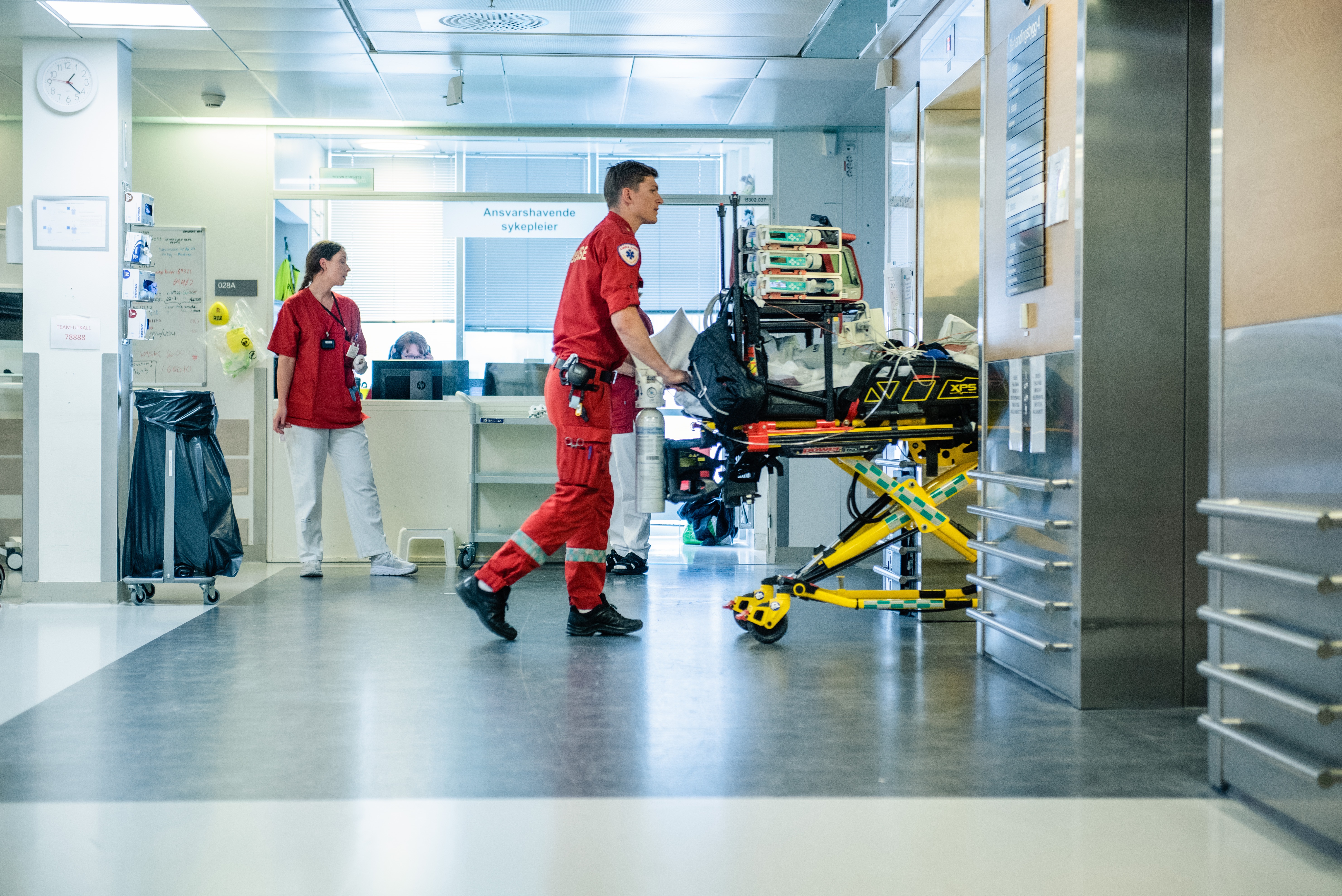 Ambulansepersonell triller en tom seng inn i heis.