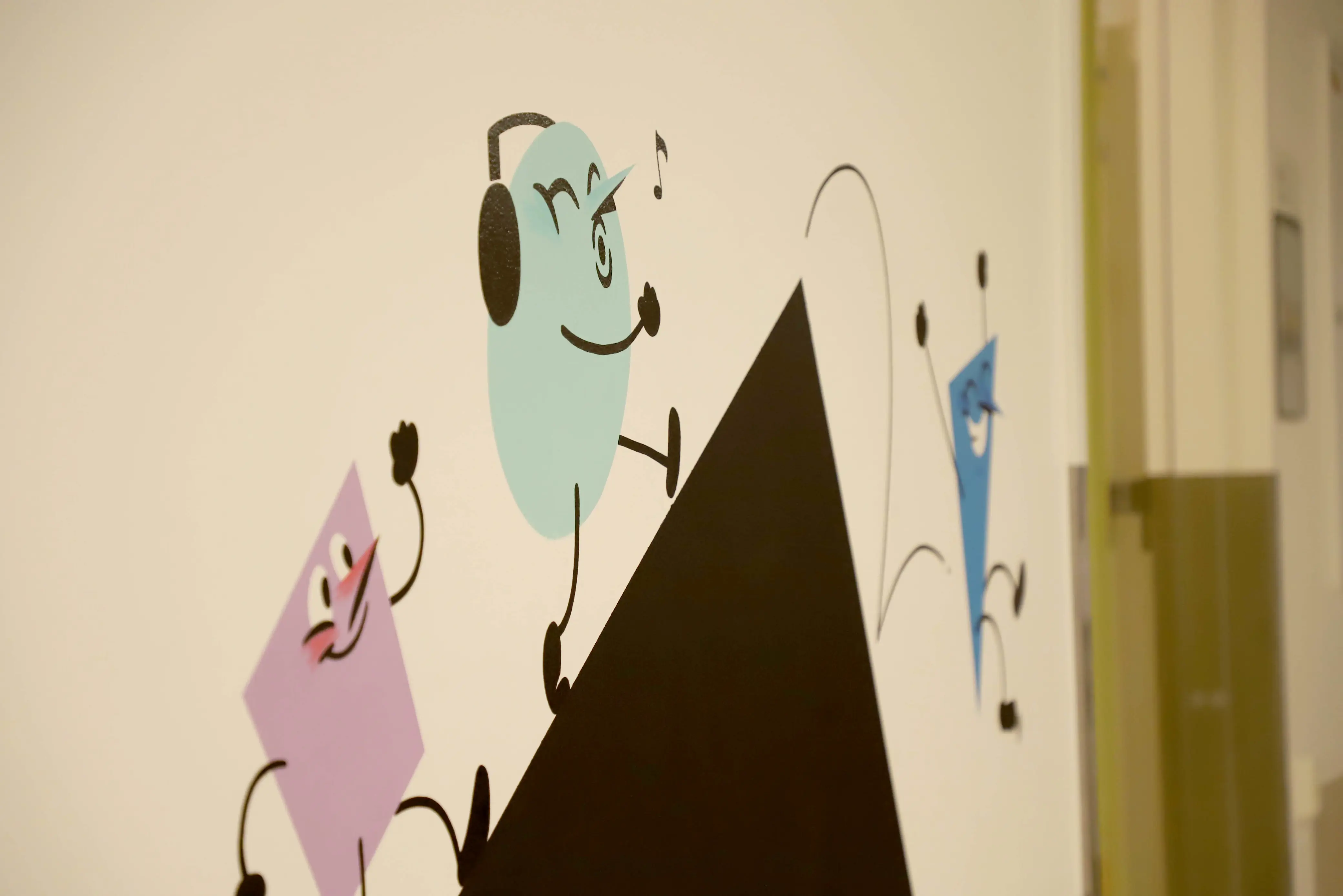 Grafitti på vegg. En blå, runn mann plystrer og hører på musikk.