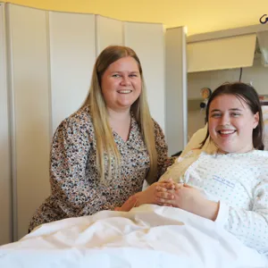 Et par kvinner i en seng