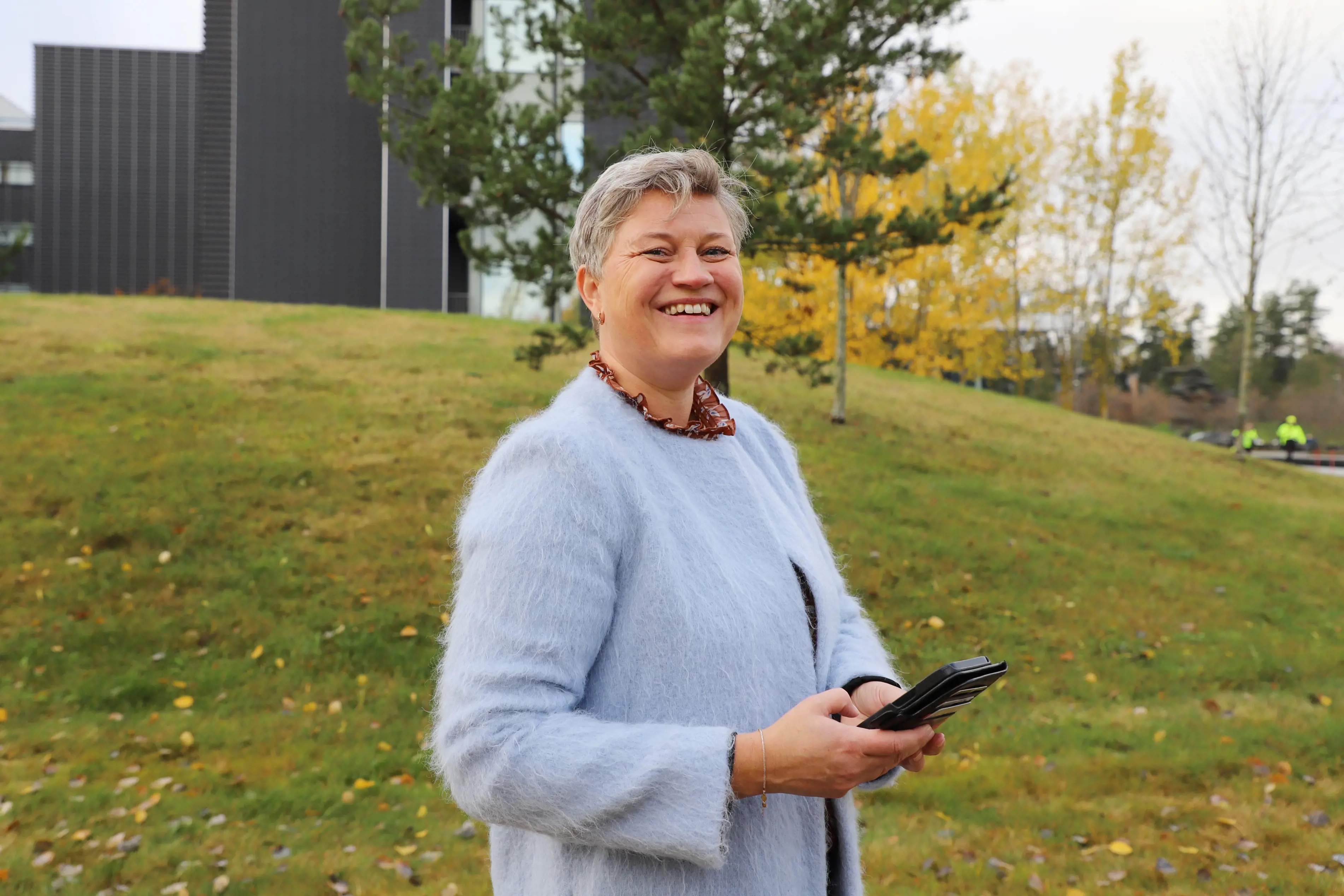 Pasienten Melinda med mobil foran Akershus universitetssykehus.