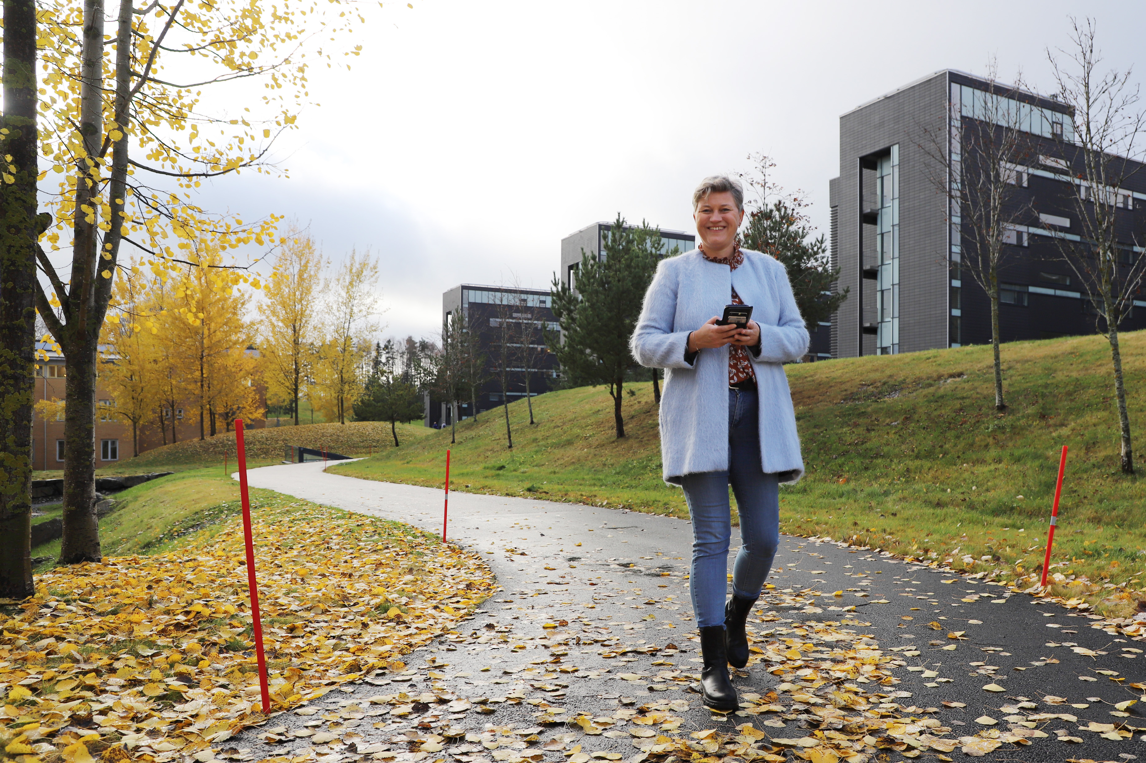 Dame med mobil foran Akershus universitetssykehus.