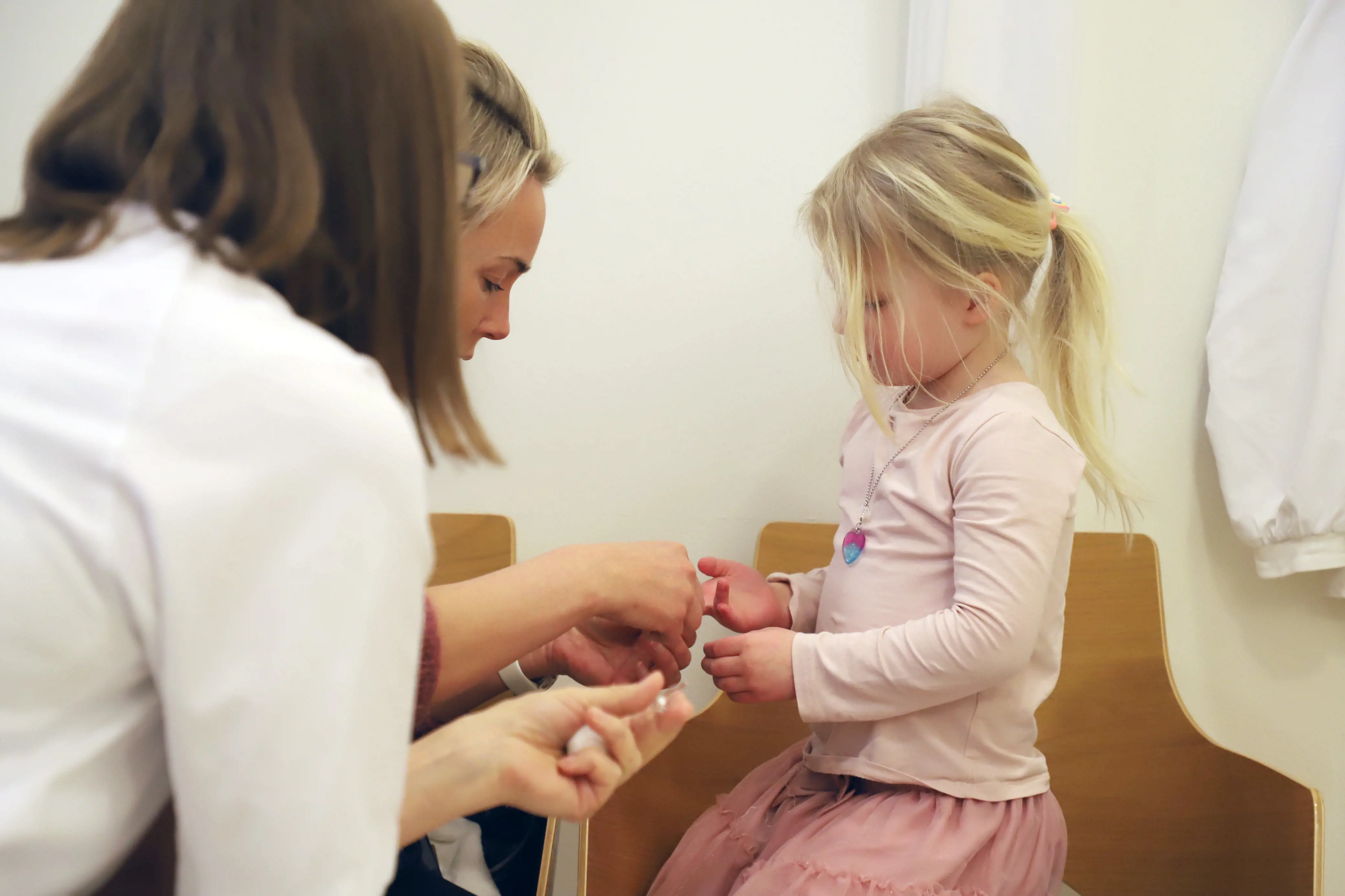 Sykepleier og mor måler blodsukker på fire år gammel jente.