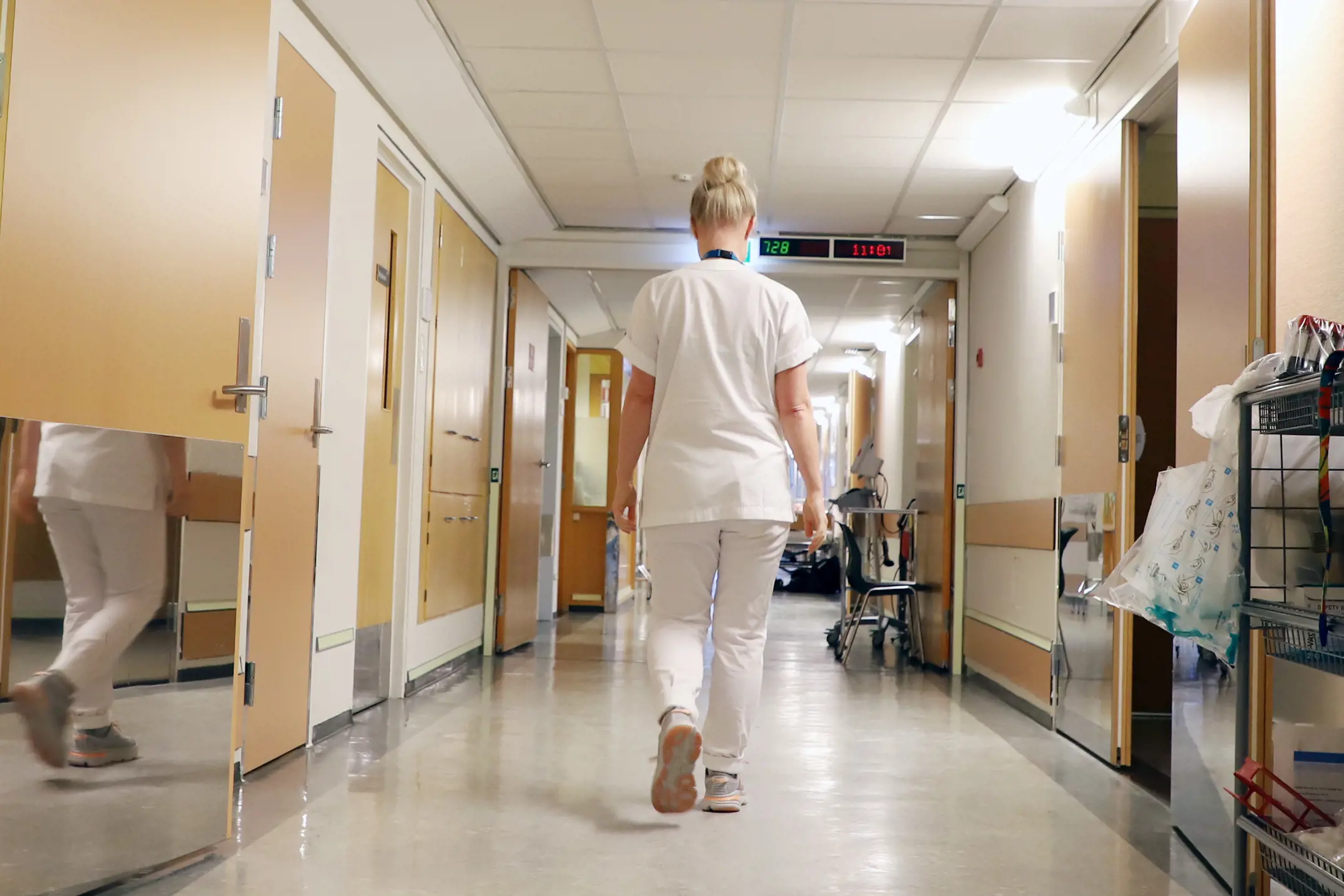 Sykepleier går i korridor. 