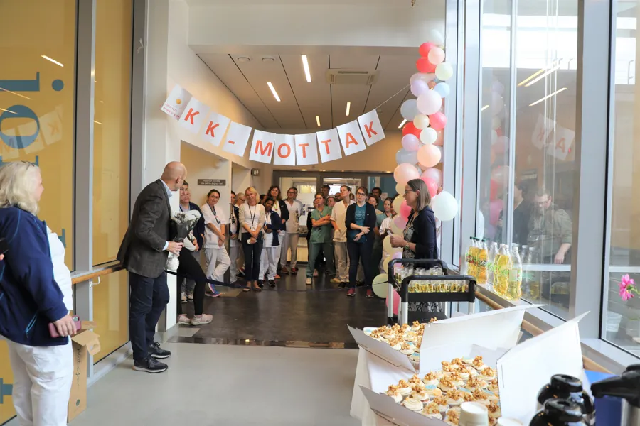 Samling av mennesker feirer med snorklipping i gang.