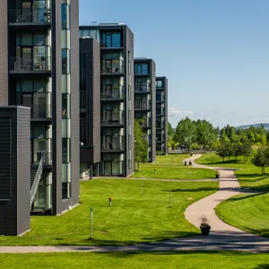 En bygning med plen og trær