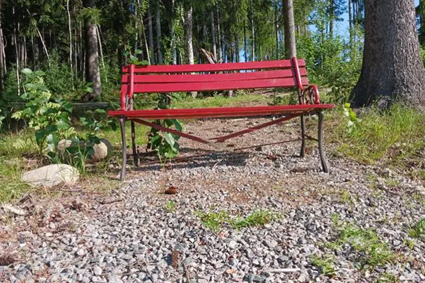 En rød benk i skogen