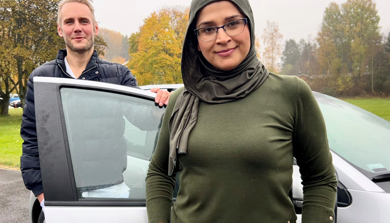 En person som står ved siden av en bil