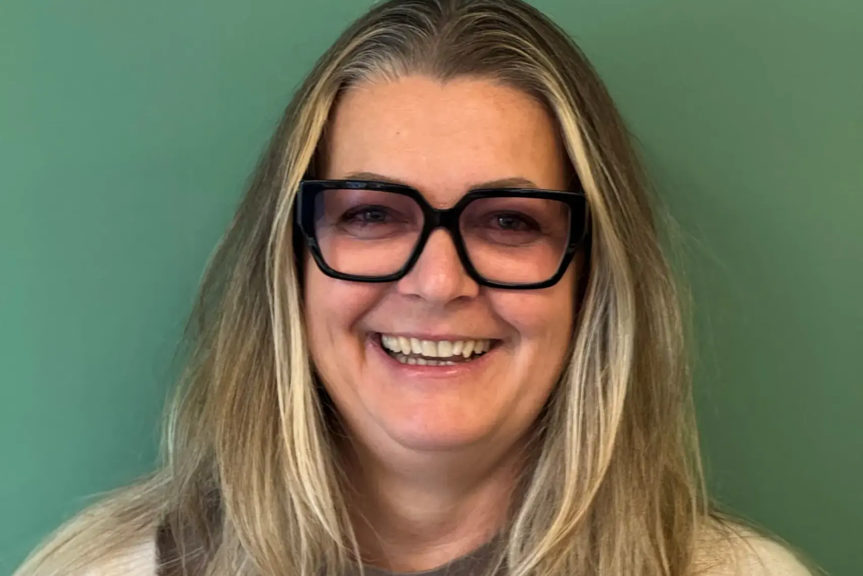 En person med langt hår som smiler