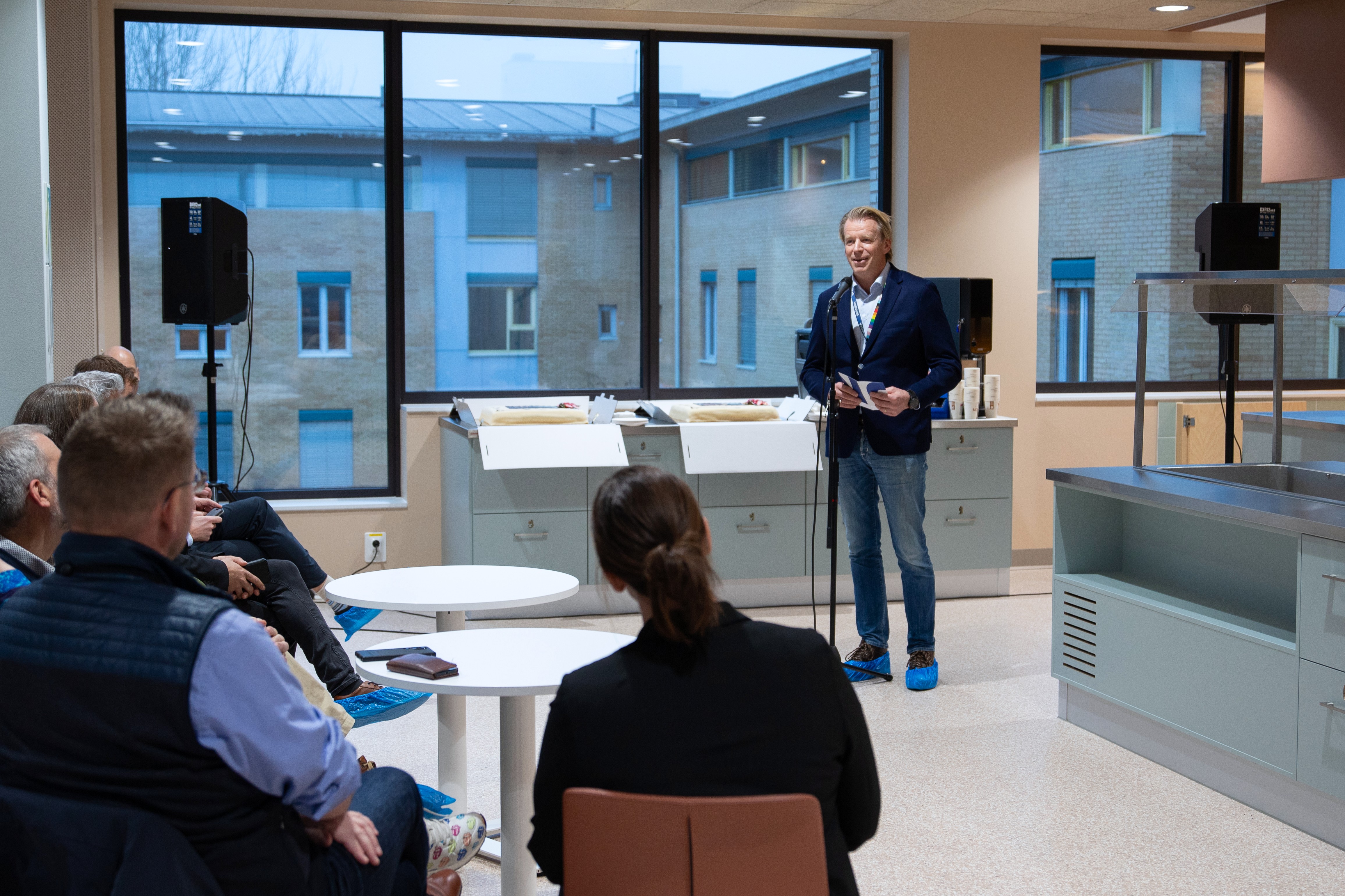 En person som står foran en gruppe mennesker som sitter ved bord