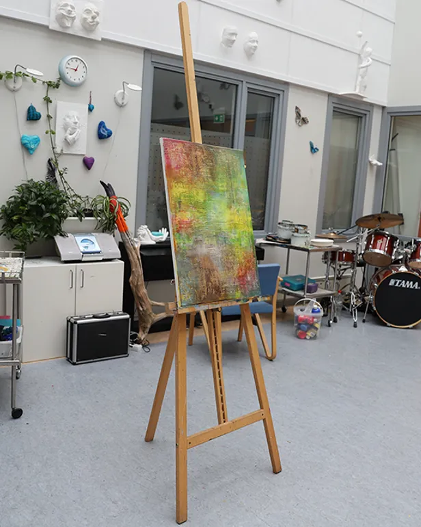 Et rom med et trommesett og et bord med en plante på