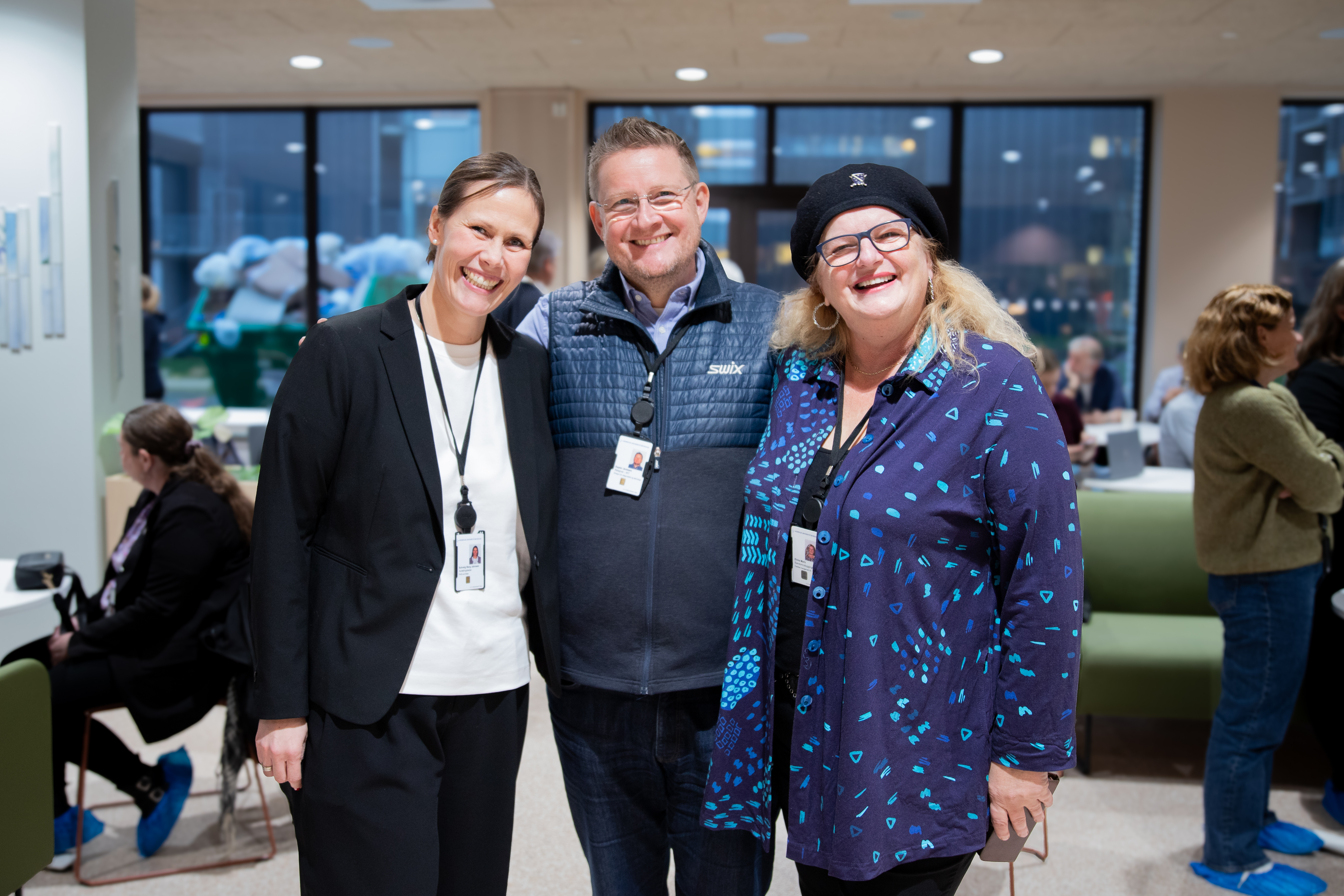 tre mennesker ser mot kamera