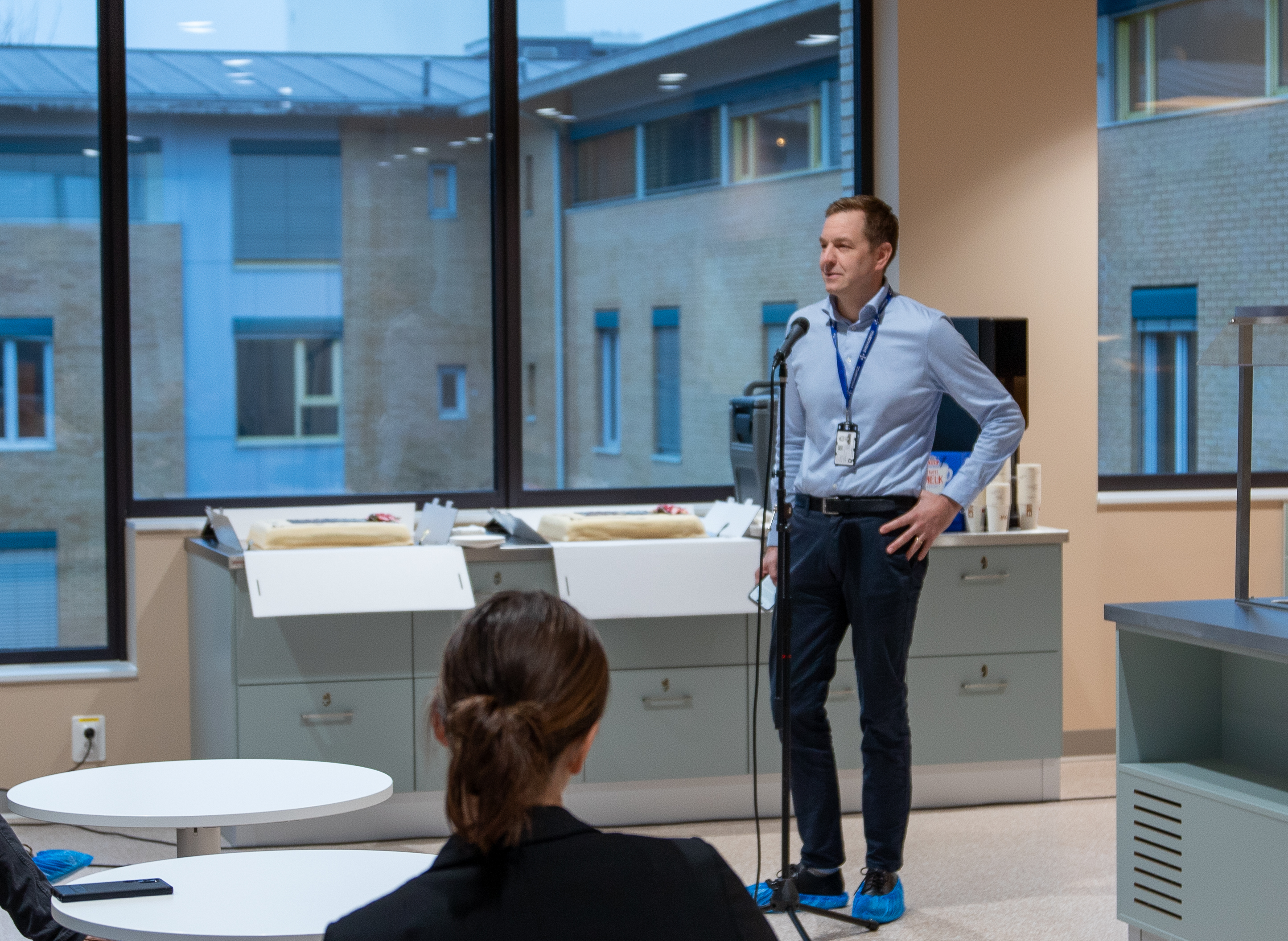 En mann som står foran en mikrofon foran en kvinne