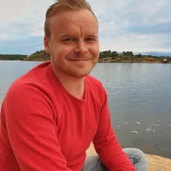 En person som sitter på en strand