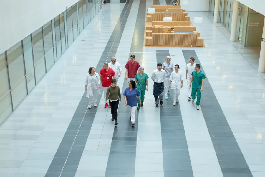 En gruppe mennesker som går nedover inne på et syskehus